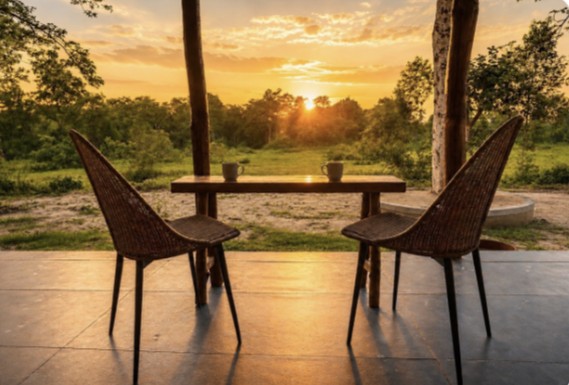 A private veranda overlooking the forest at sunset